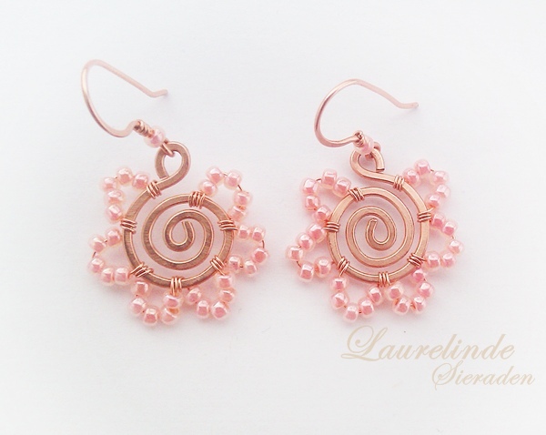 koperen spiraaloorbellen met zalmroze bloemblaadjes